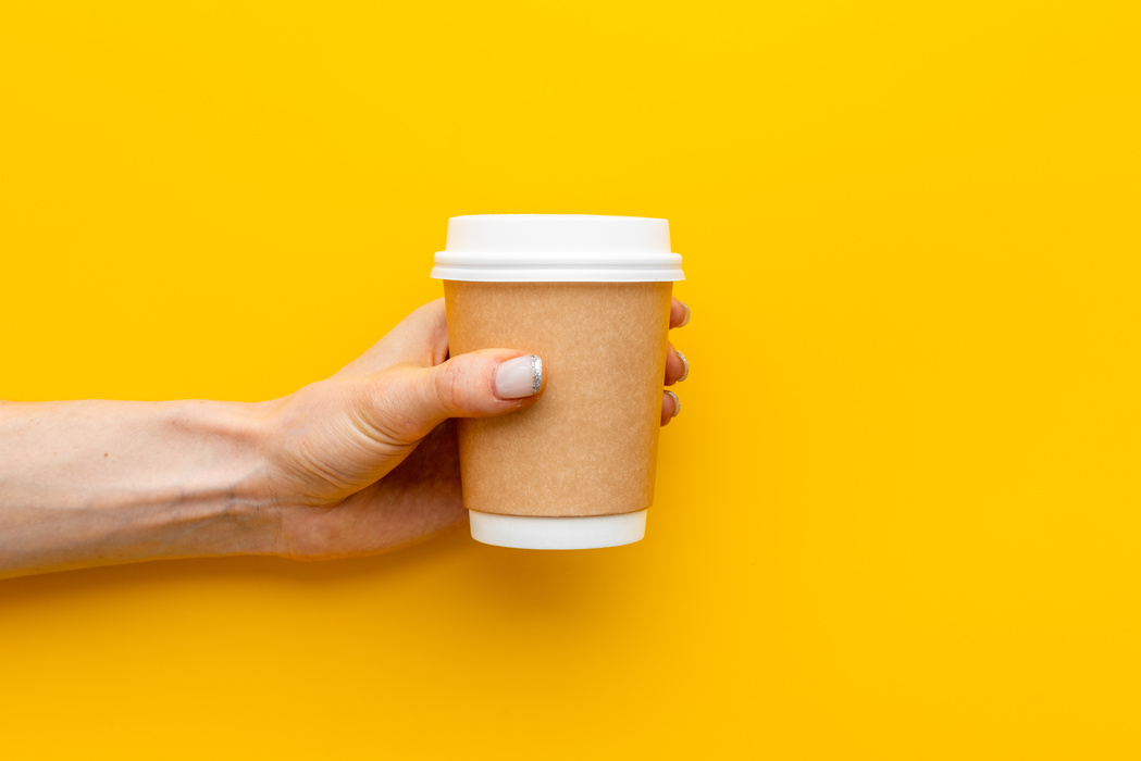 Paper cup with coffee in hand. Coffee take away concept
